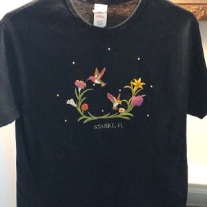 Black cotton souvenir T-shirt with floral detail.